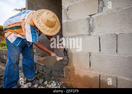 Un ouvrier de la construction est en voie de construire une nouvelle maison à Las Minas de Tulu, province de Cocle, République de Panama, Amérique centrale. Banque D'Images