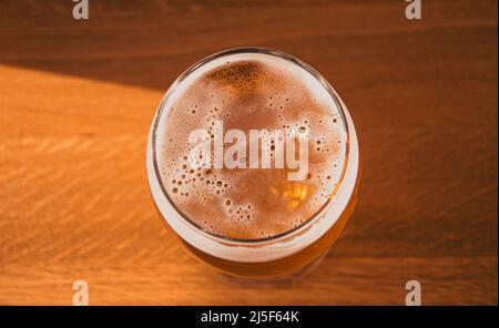 Verre de bière sur une table ensoleillée. Une délicieuse bière en verre. Banque D'Images