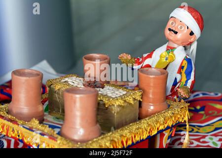 Le Caire, Egypte, Mars 26 2022: Un décor de Ramadan fond d'un homme qui vend des graines lupin et des fèves fava par un chariot décoratif avec Kheyameya de Ra Banque D'Images