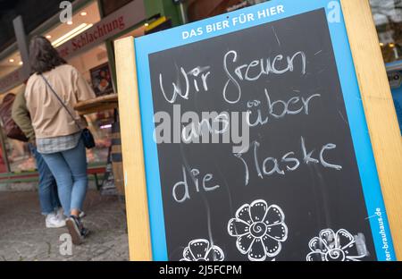 Munich, Allemagne. 23rd avril 2022. Un panneau indiquant « nous sommes heureux du masque » se trouve devant un magasin sur le Viktualienmarkt. Depuis le début du mois d'avril, il n'est plus nécessaire de porter des masques dans la plupart des régions d'Allemagne, du moins lors des achats. Mais la prudence prévaut chez de nombreux clients. Credit: Peter Kneffel/dpa/Alay Live News Banque D'Images