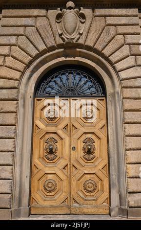 Anciennes portes en bois massif ornées de décorations sculptées à la main par des artistes locaux, dans le splendide centre historique de Lucques Banque D'Images