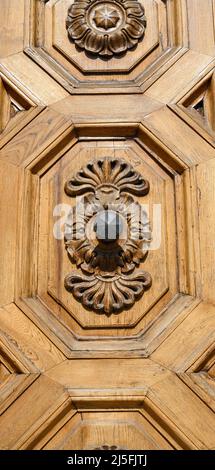 Anciennes portes en bois massif ornées de décorations sculptées à la main par des artistes locaux, dans le splendide centre historique de Lucques Banque D'Images