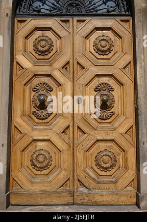 Anciennes portes en bois massif ornées de décorations sculptées à la main par des artistes locaux, dans le splendide centre historique de Lucques Banque D'Images