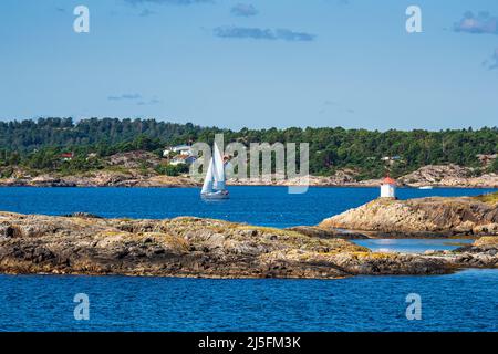 Phare et voilier sur l'archipel de Merdø en Norvège. Banque D'Images