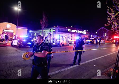 Bloomington, États-Unis. 23rd avril 2022. Des membres des forces de l'ordre travaillent sur les lieux d'une fusillade qui a fait trois blessés au Kalao Night Club sur North Walnut Street. La police a également localisé une quatrième victime de coups de feu à un autre endroit sur 6th Street, mais il n'était pas clair si les fusillades étaient liées, et la police traite la scène comme une enquête séparée. Puis, un certain temps plus tard, la police a poursuivi un véhicule avant qu'il ne s'écrase sur le campus de l'Université de l'Indiana. Les occupants du véhicule couraient à pied, il n'est pas clair si le véhicule était connecté aux tirs. Crédit : SOPA Images Limited/Alamy Live News Banque D'Images