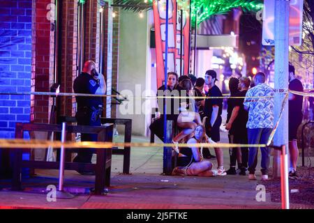 Bloomington, États-Unis. 23rd avril 2022. Des membres des forces de l'ordre travaillent sur les lieux d'une fusillade qui a fait trois blessés au Kalao Night Club sur North Walnut Street. La police a également localisé une quatrième victime de coups de feu à un autre endroit sur 6th Street, mais il n'était pas clair si les fusillades étaient liées, et la police traite la scène comme une enquête séparée. Puis, un certain temps plus tard, la police a poursuivi un véhicule avant qu'il ne s'écrase sur le campus de l'Université de l'Indiana. Les occupants du véhicule couraient à pied, il n'est pas clair si le véhicule était connecté aux tirs. Crédit : SOPA Images Limited/Alamy Live News Banque D'Images