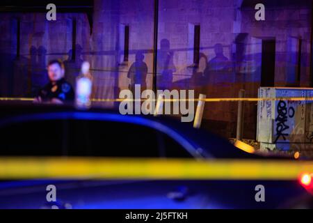 Bloomington, États-Unis. 23rd avril 2022. Des membres des forces de l'ordre travaillent sur les lieux où une quatrième victime a été retrouvée après une fusillade antérieure qui a fait trois blessés au Kalao Night Club sur North Walnut Street. La police a également localisé une quatrième victime de coups de feu à un autre endroit sur 6th Street, mais il n'était pas clair si les fusillades étaient liées, et la police traite la scène comme une enquête séparée. Puis, un certain temps plus tard, la police a poursuivi un véhicule avant qu'il ne s'écrase sur le campus de l'Université de l'Indiana. Les occupants du véhicule couraient à pied, il n'est pas clair si le véhicule était relié à la fusillade Banque D'Images