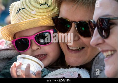 La première ministre écossaise, Nicola Sturgeon, parle avec un tout-petit lorsqu'elle visite le marché agricole de Partick, à Glasgow, alors qu'elle est sur la piste de campagne des élections du conseil. Date de la photo: Samedi 23 avril 2022. Banque D'Images