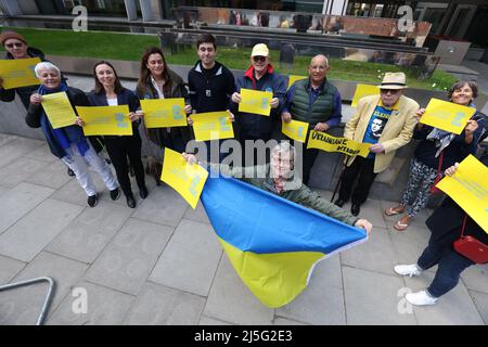 Le porte-drapeau Myron Tytko et d'autres supporters portent des bannières alors qu'ils se joignent à un groupe d'hôtes, de sponsors et de partisans des réfugiés ukrainiens, tiennent une Vigile pour les visas à l'extérieur du Home Office à Londres. Date de la photo: Samedi 23 avril 2022. Banque D'Images