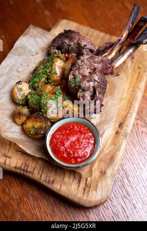 viande sur l'os avec pommes de terre et sauce. Banque D'Images