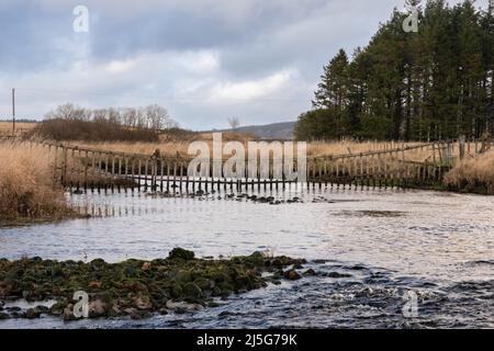 Un watergate suspendu au-dessus de la rivière Carsphain Lane au confluent avec l'eau de Deugh en hiver, Dumfries et Galloway Ecosse Banque D'Images