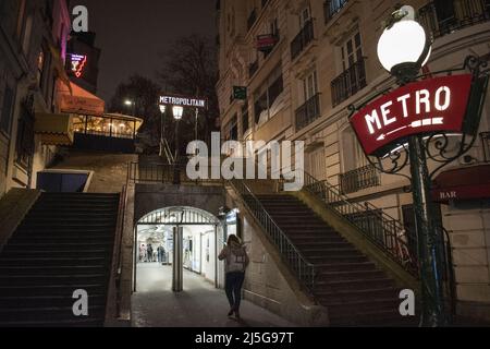 Paris, France : vue de nuit, feux de rue et enseignes au néon à l'entrée de la station de métro Montmartre, célèbre colline dans le nord du 18th arrondissement Banque D'Images
