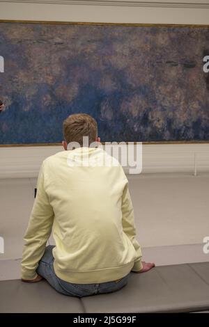 Paris, France, Europe: Visiteur devant les Nymphées (Lies d'eau), célèbre série de panneaux décoratifs de Claude Monet au Musée de l'Orangerie Banque D'Images
