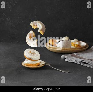 lévitation beignets de carottes cassés avec de la crème empilée sur un fond sombre. espace de copie Banque D'Images