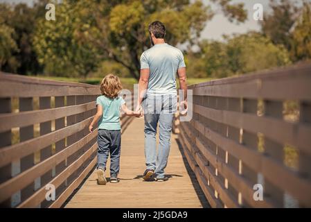 fête des pères. père et fils marchant à l'extérieur avec vue arrière. valeur pour la famille. enfance et parentalité. Banque D'Images