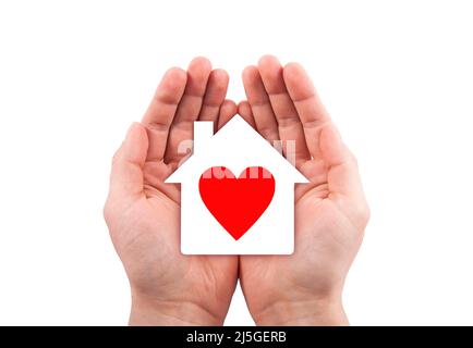 Maison en papier avec coeur rouge découpé dans les mains isolées sur fond blanc avec chemin de coupure. Banque D'Images