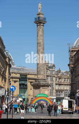 Photo verticale du monument de Grays, Newcastle upon Tyne, Royaume-Uni, avec des gens magasiner et un arc-en-ciel de boîtes en aluminium en dessous, en favorisant le recyclage. Banque D'Images