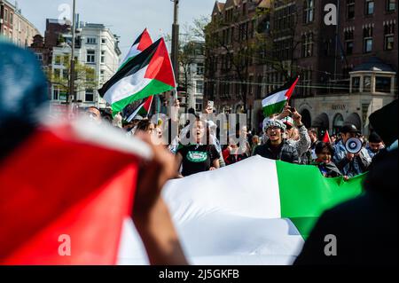 Les manifestants scandent des slogans contre Israël tout en tenant un grand drapeau palestinien pendant la manifestation. Des centaines de personnes se sont rassemblées sur la place du Dam à Amsterdam pour montrer leur soutien à la Palestine et dénoncer les récentes violences du gouvernement israélien contre les Palestiniens. La « manifestation d'urgence » a été organisée en réponse à la dernière agression d'Israël contre les Palestiniens le 15 avril à la mosquée Al-Aqsa à Jérusalem. Plus de 150 Palestiniens ont été blessés en jetant des pierres et des feux d'artifice et les forces israéliennes ont tiré des grenades lacrymogènes et des gaz lacrymogènes. Banque D'Images