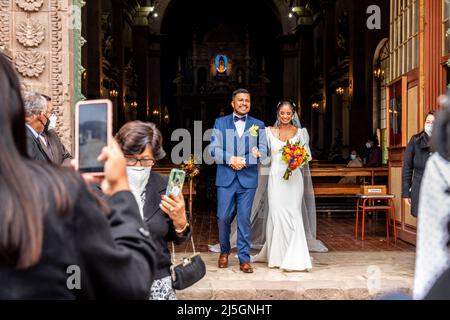 Un jeune couple péruvien quitte la cathédrale après s'être marié, la Plaza de Armas, Puno, Pérou. Banque D'Images