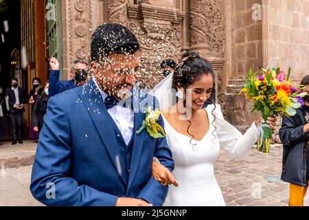 Un jeune couple péruvien quitte la cathédrale après s'être marié, la Plaza de Armas, Puno, Pérou. Banque D'Images