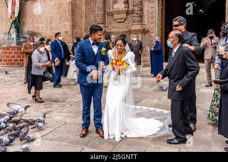 Un jeune couple péruvien quitte la cathédrale après s'être marié, la Plaza de Armas, Puno, Pérou. Banque D'Images