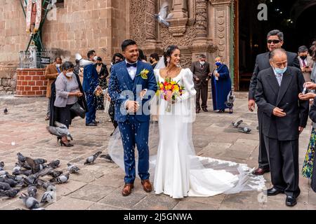 Un jeune couple péruvien quitte la cathédrale après s'être marié, la Plaza de Armas, Puno, Pérou. Banque D'Images