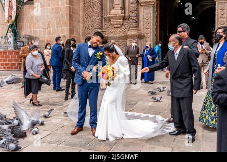 Un jeune couple péruvien quitte la cathédrale après s'être marié, la Plaza de Armas, Puno, Pérou. Banque D'Images