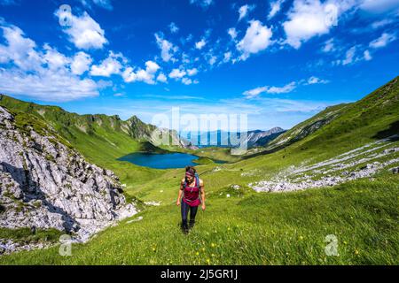 Belle femme est en randonnée au lac Schrecksee thourgh montagne pré dans les alpes bavaroises Banque D'Images