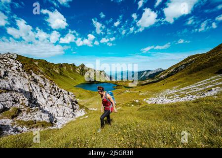 Belle femme est en randonnée au lac Schrecksee thourgh montagne pré dans les alpes bavaroises Banque D'Images