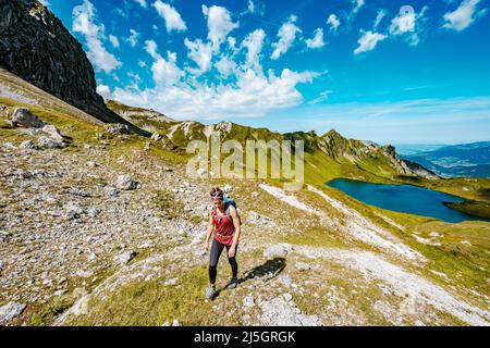 Belle femme est en randonnée au lac Schrecksee thourgh montagne pré dans les alpes bavaroises Banque D'Images