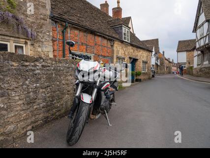 White triomphe Street triple S moto garée dans un village de 18th siècle rue Lacock Wiltshire Banque D'Images