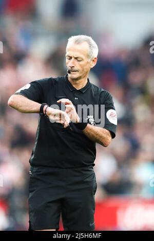 LONDRES, ROYAUME-UNI. 23rd AVRIL Martin Atkinson, l'arbitre du match tient le sifflet dans sa bouche après avoir signalé la fin du match de la Premier League entre Brentford et Tottenham Hotspur au stade communautaire de Brentford, Brentford, le samedi 23rd avril 2022. (Credit: Tom West | MI News) Credit: MI News & Sport /Alay Live News Banque D'Images