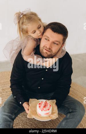 Le père et le dauther célèbrent l'anniversaire de leur petite fille.Fête d'anniversaire en robes avec gâteau. Banque D'Images