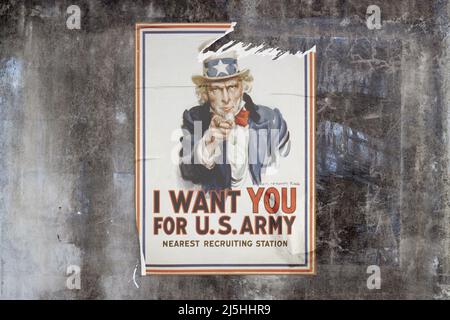 Mur en béton recouvert d'intempéries plein cadre avec une affiche déchirée au milieu représentant l'oncle Sam avec « Je veux que vous pour l'armée américaine - station de recrutement la plus proche » Banque D'Images