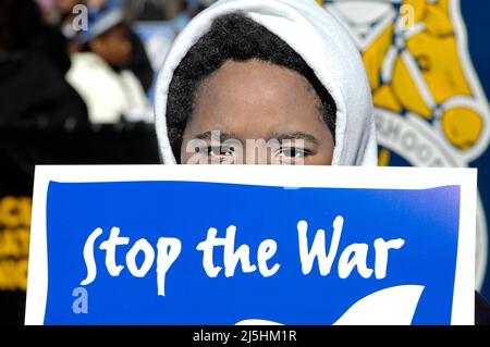 Jeune garçon noir ethnique au rassemblement de manifestation anti-guerre à Atlanta, en Géorgie, regardant la caméra avec le signe Stop the War Banque D'Images