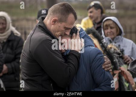 Bucha, Ukraine. 23rd avril 2022. Andrii, 42, à gauche, Compostees Tromssa Iryna, 55, Pendant les services de sépulture de Tromssa Bogdan Volodymerovuch, 24 ans, dans un cimetière de Bucha, en Ukraine, le samedi 23 avril 2022. Volodymerovuch était paratrooper dans la brigade de 95, est mort quelque part entre Symu et Kharkiv. Son corps était presque méconnaissable. Photo de Ken Cedeno/UPI crédit: UPI/Alay Live News Banque D'Images