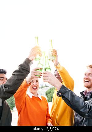 Groupe vertical de personnes diverses en train de jouer à l'extérieur en buvant de la bière et en s'amusant. Des amis heureux célébrant ensemble le succès Banque D'Images