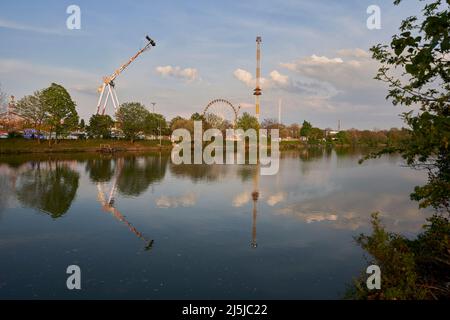 Stuttgart, Allemagne - 22 avril 2022 : festival de printemps (Fühlingsfest) avec manèges et carrousels amusants au bord de la rivière le soir. Allemagne, Stuttgart, Wasen. Banque D'Images