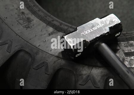 Tire sledgehammer crossfit roue noire entraînement athlète musculation exercice, de l'effort style de vie dans l'entraînement et la puissance de gym, sportswear sain Banque D'Images