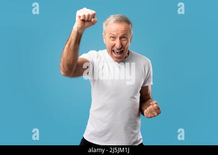 Portrait d'un homme mûr excité criant des poings secouants Banque D'Images