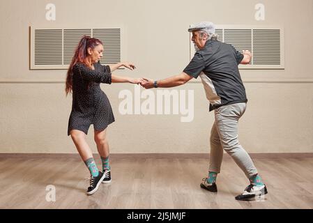 Couple de danse faisant un mouvement de danse de saut de lindy Banque D'Images