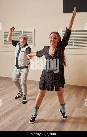 Couple adulte senior dansant le saut de lindy dans une salle de bal Banque D'Images