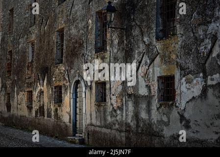 Façade de la maison mystère avec grilles en fer rouillé aux fenêtres. Strassoldo, Udine, Friuli Venezia Giulia, Italie. Banque D'Images