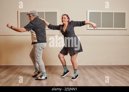 Couple de danse faisant un mouvement de danse de saut de lindy Banque D'Images