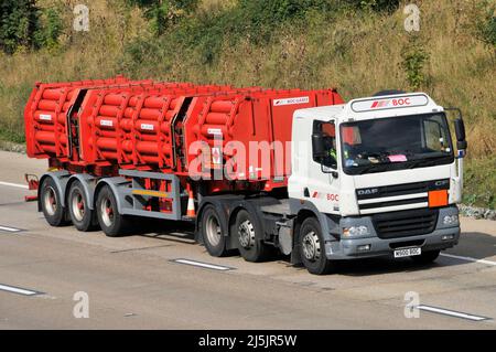 Vue latérale avant d'un camion et conducteur DAF hgv de BOC Gas avec remorque articulée de cylindres rouges contenant des gaz BOC sur autoroute britannique Banque D'Images