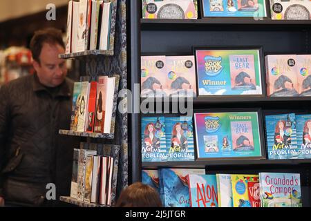 (220424) -- STRATFORD-UPON-AVON, 24 avril 2022 (Xinhua) -- Un homme lit dans une librairie de Stratford-upon-Avon, en Grande-Bretagne, 23 avril 2022. Plus de 1 000 personnes se sont rassemblées à Stratford-upon-Avon, la ville natale de William Shakespeare, pour célébrer samedi l'anniversaire du dramaturge britannique en 458th. (Xinhua/Li Ying) Banque D'Images