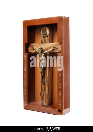 Crucifix en bois debout dans une boîte sur fond blanc Banque D'Images