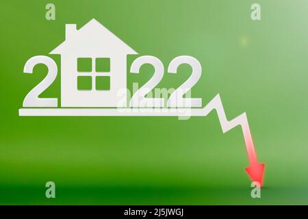 Valeur immobilière en 2022. Vente et effondrement de la valeur de l'immobilier. Inflation et hausse des prix. Modèle de maison sur fond vert. Chiffres 2022 Banque D'Images