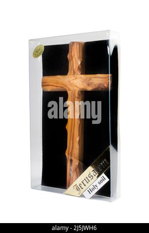 Crucifix en bois debout dans une boîte sur fond blanc Banque D'Images