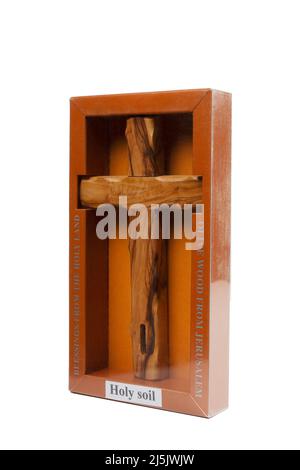 Crucifix en bois debout dans une boîte sur fond blanc Banque D'Images